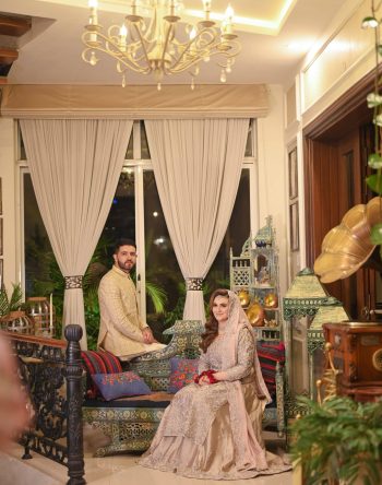 An elegant indoor wedding portrait featuring the bride and groom in a beautifully decorated venue, professionally photographed by Shahzaib Studios. Bride and groom indoor wedding portrait in an elegant setting captured by Shahzaib Studios, professional wedding photographer in Islamabad, Rawalpindi, and Wah Cantt.